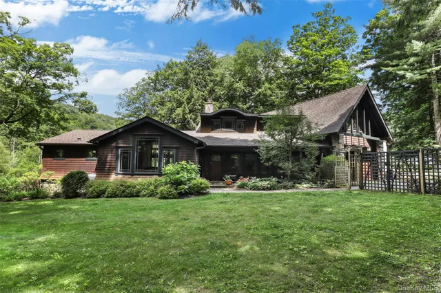 a front view of a house with a yard and trees