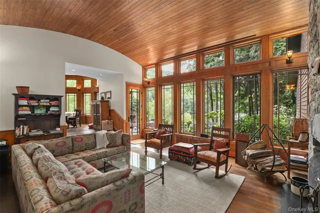 a living room with furniture fireplace and floor to ceiling windows