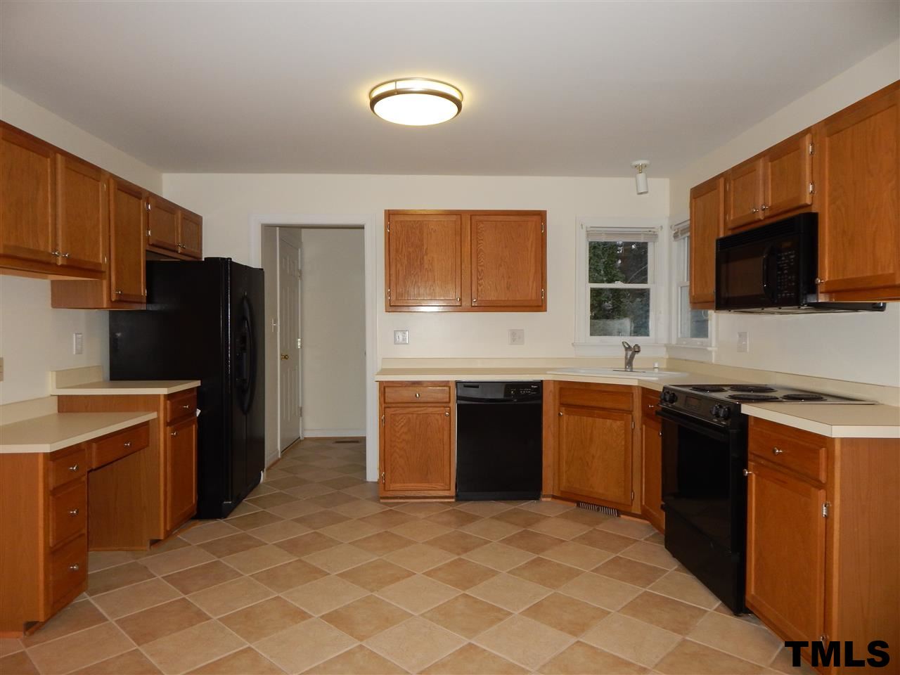 4121 Fowler Ridge Drive Raleigh, NC 27616 - Photo 5 of 20 a kitchen with stainless steel appliances granite countertop a stove top oven a sink dishwasher and a refrigerator with wooden cabinets