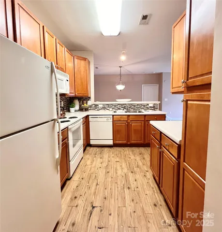 a kitchen with stainless steel appliances granite countertop a refrigerator a stove a sink and a refrigerator