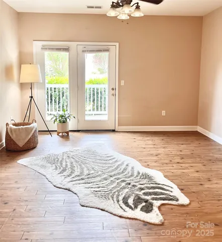 a view of a bedroom with a bed and wooden floor