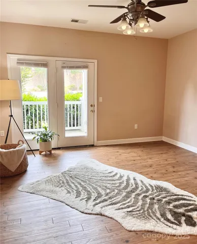 a view of a bedroom with a bed and wooden floor