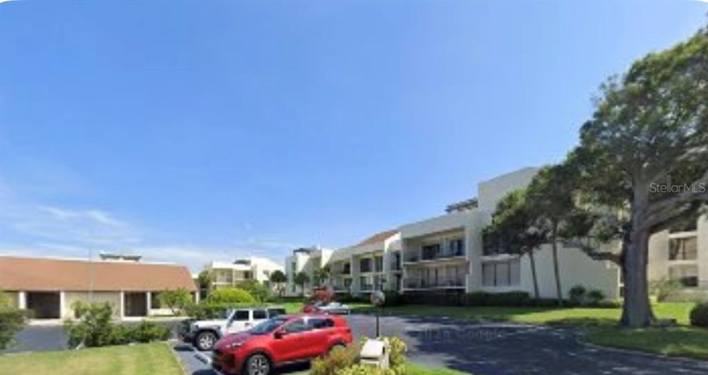 50 Coe Road, Unit 322 Belleair, FL 33756 - Photo 4 of 22 a front view of a house with a garden and tree