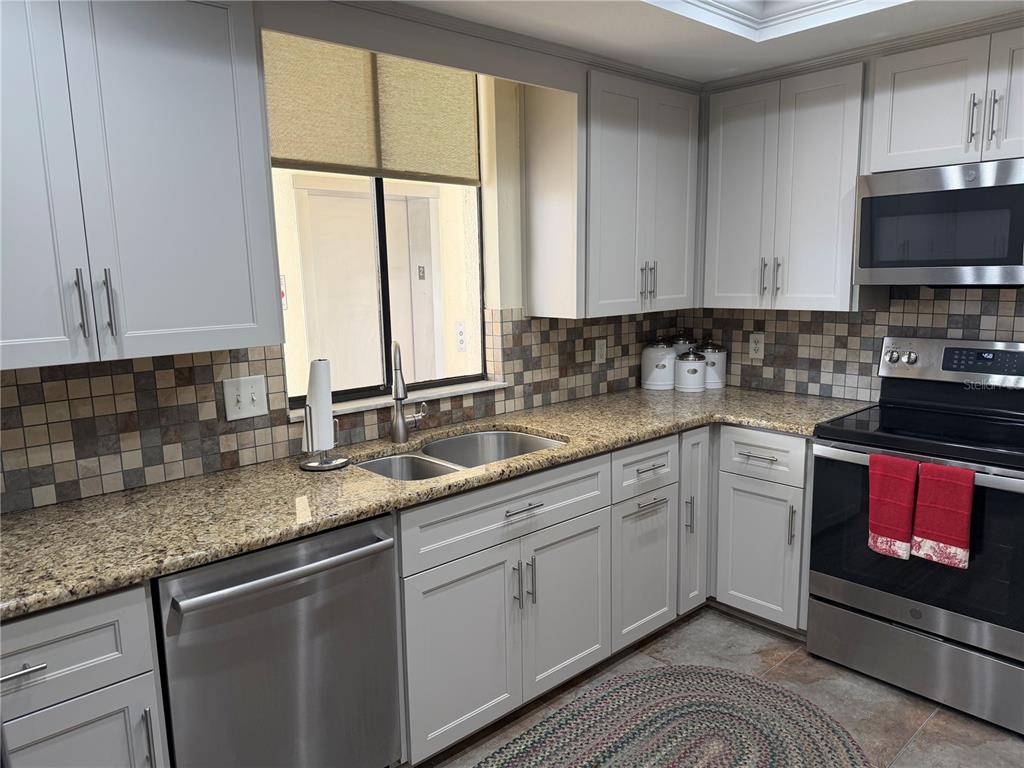 50 Coe Road, Unit 322 Belleair, FL 33756 - Photo 9 of 22 a kitchen with stainless steel appliances granite countertop a sink a stove and cabinets