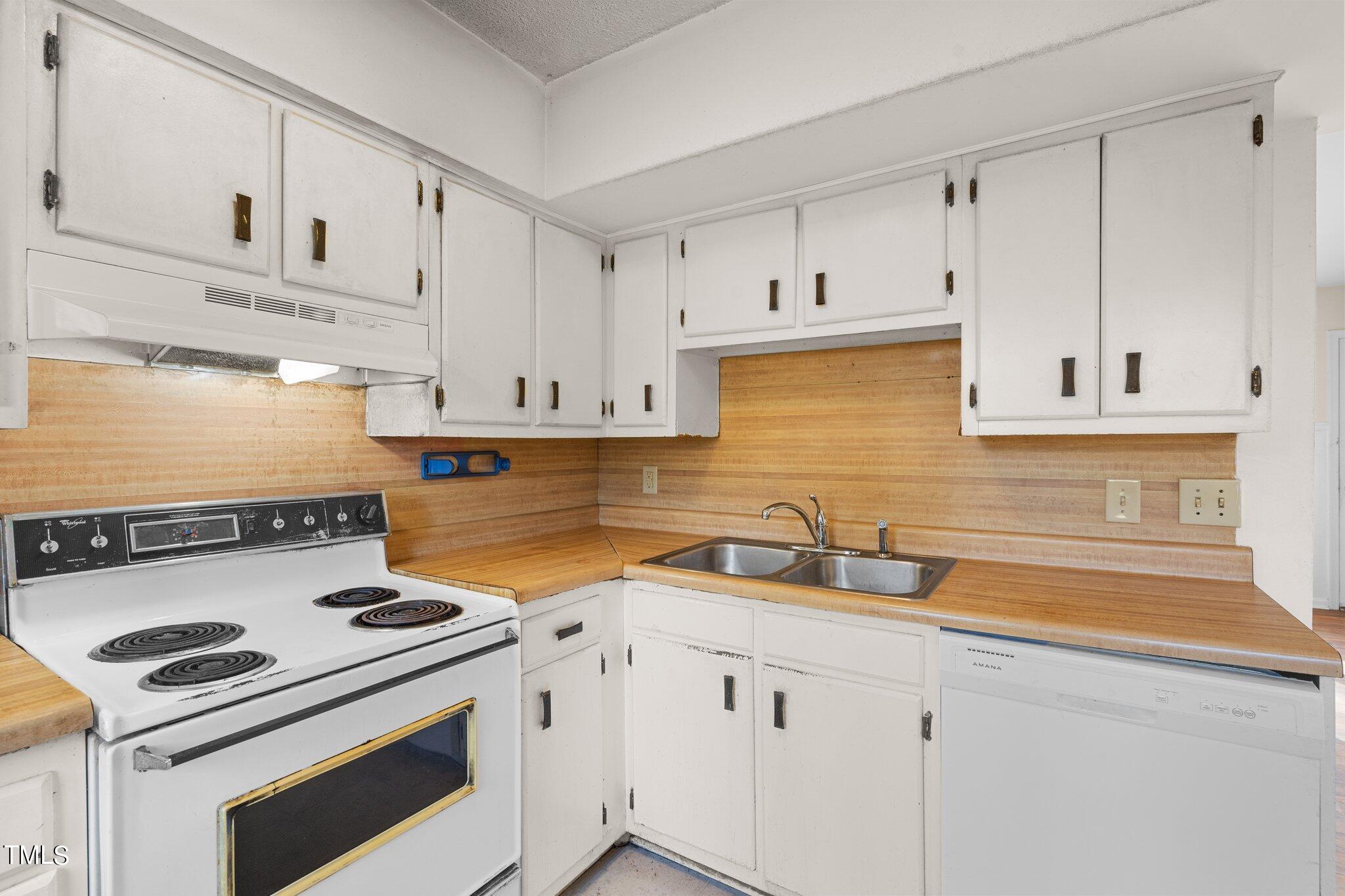 5210 Vann Street Raleigh, NC 27606 - Photo 10 of 28 a kitchen with white cabinets and appliances