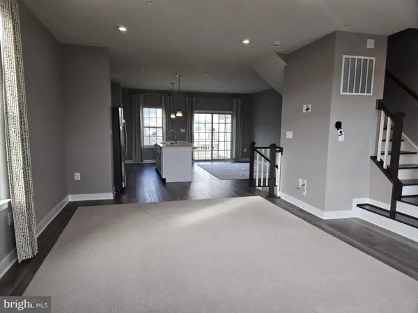 a view of a living room with furniture and wooden floor