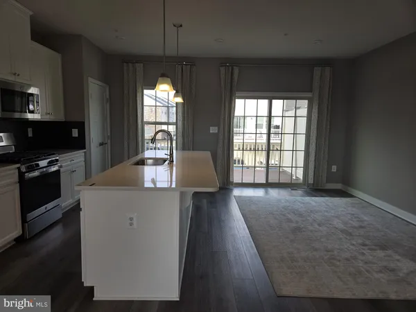 a kitchen with granite countertop a stove a sink a refrigerator and a fireplace
