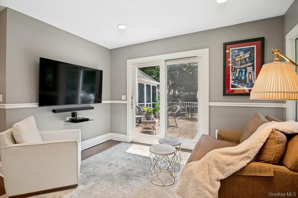312 Quaker Road Chappaqua, NY 10514 - Photo 14 of 36 a living room with furniture a flat screen tv and a floor to ceiling window
