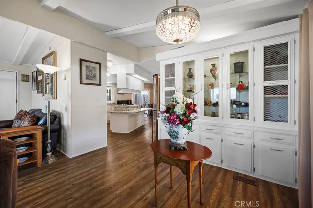 a view of a dining room and livingroom with furniture wooden floor a chandelier