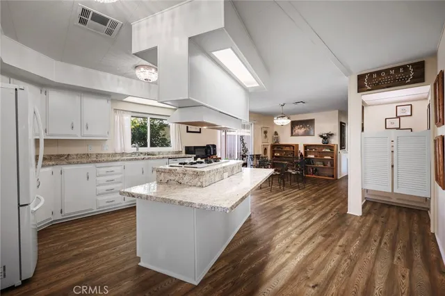a kitchen with stainless steel appliances sink refrigerator stove and wooden floor