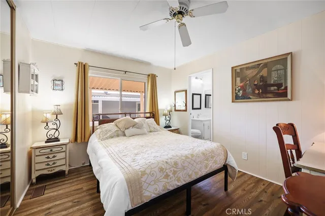 a bedroom with a bed a large window with table and chair