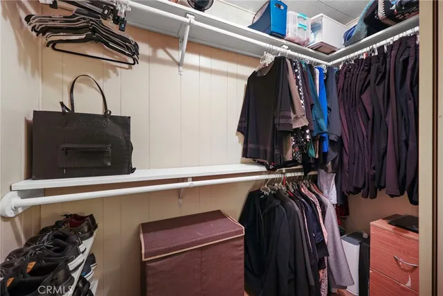 a view of walk in closet with clothes and shoes