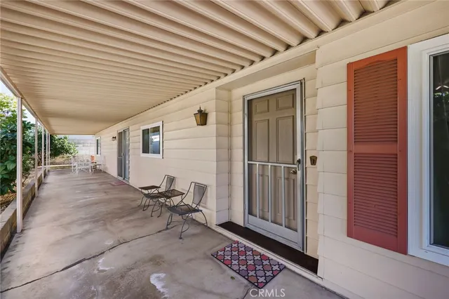 a view of a patio with table and chairs and a barbeque