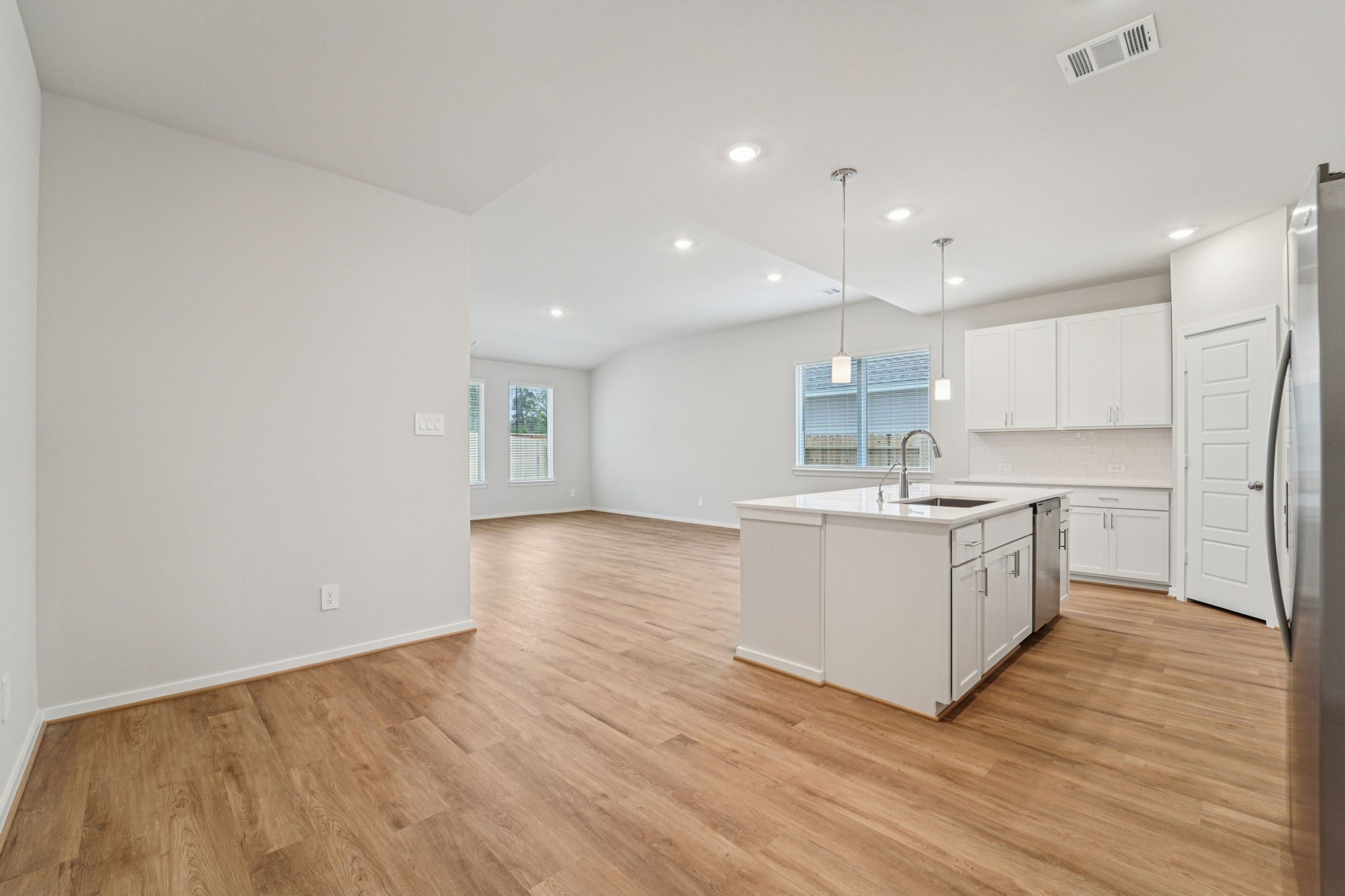 16217 Parish Pointe Court Conroe, TX 77302 - Photo 7 of 42 a kitchen with a sink wooden floor stainless steel appliances and cabinets