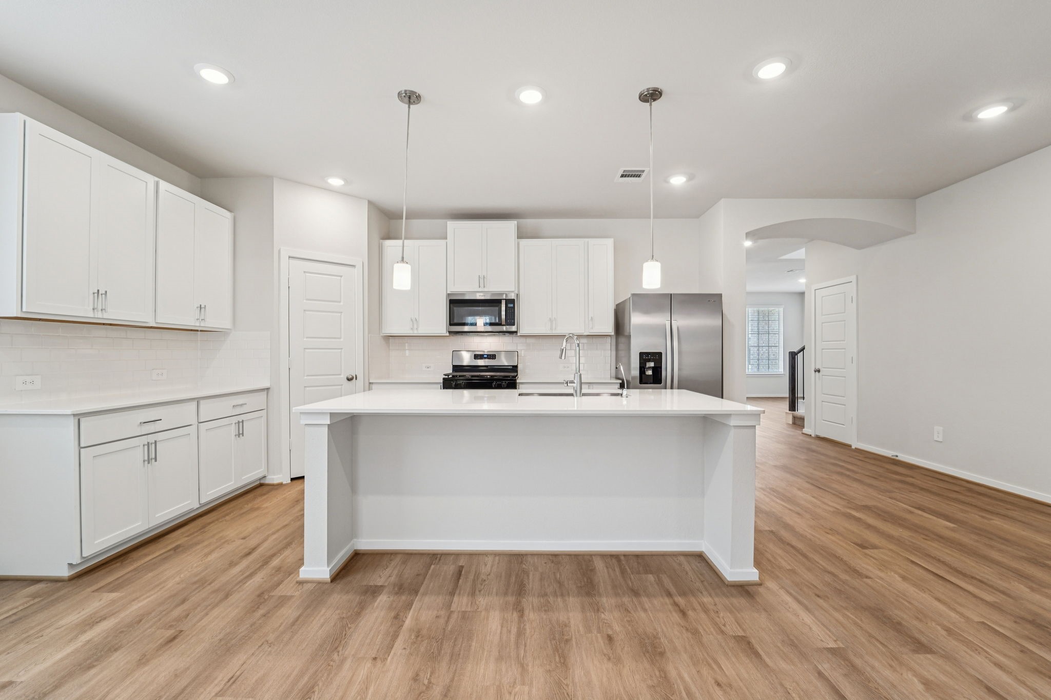 16217 Parish Pointe Court Conroe, TX 77302 - Photo 9 of 42 a open kitchen with cabinets wooden floor and stainless steel appliances