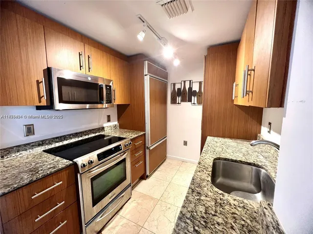 a kitchen with granite countertop a stove and a sink