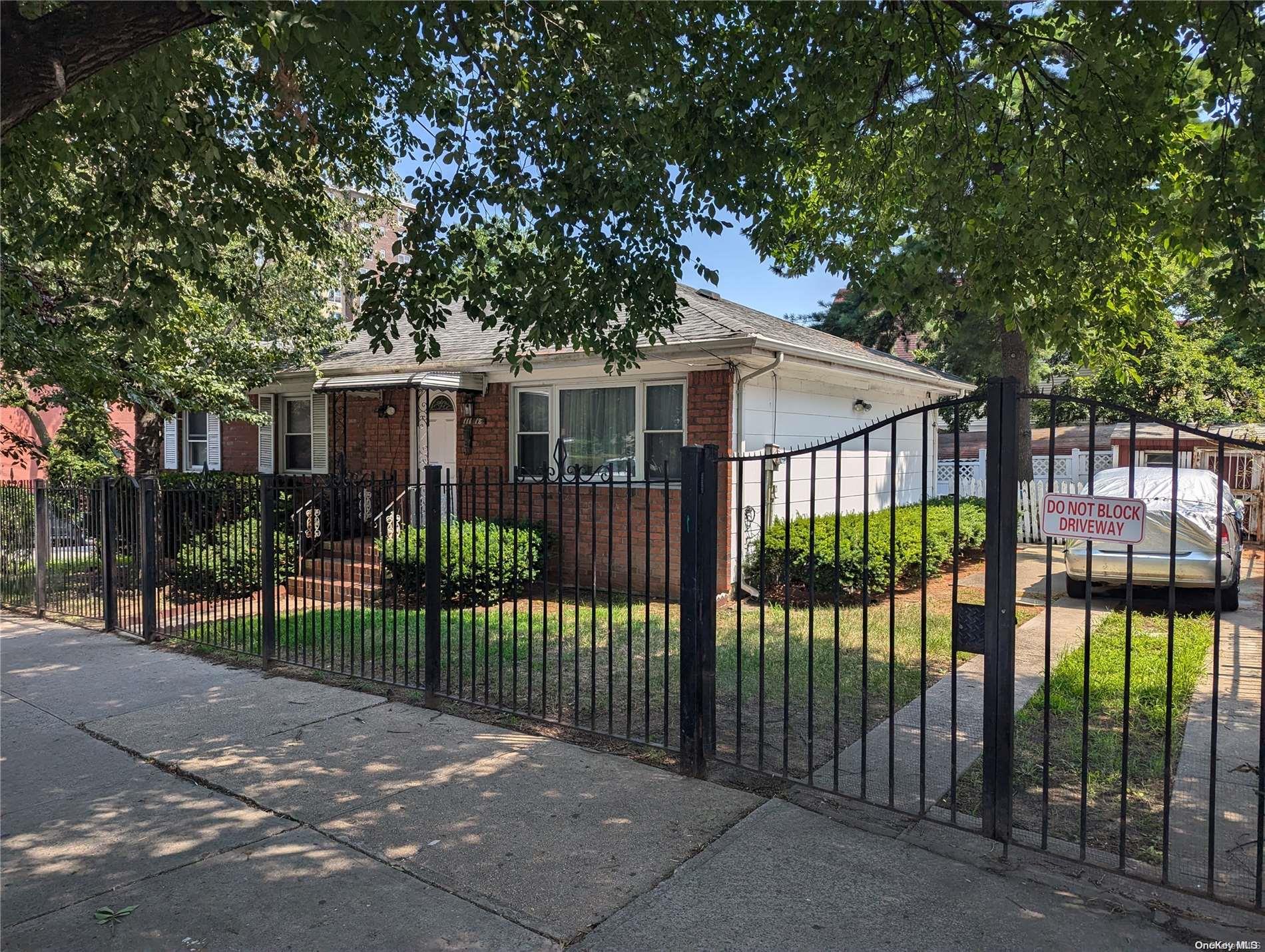 a view of a white house with a large window and plants