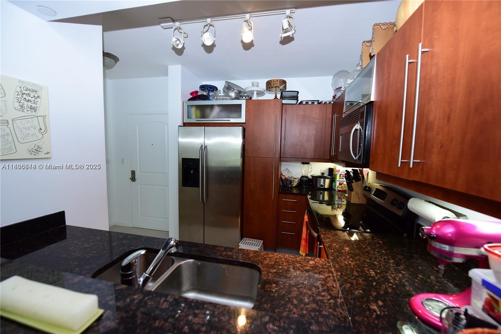 7355 Southwest 89th Street, Unit 622N Miami, FL 33156 - Photo 4 of 16 a kitchen with a refrigerator and a stove
