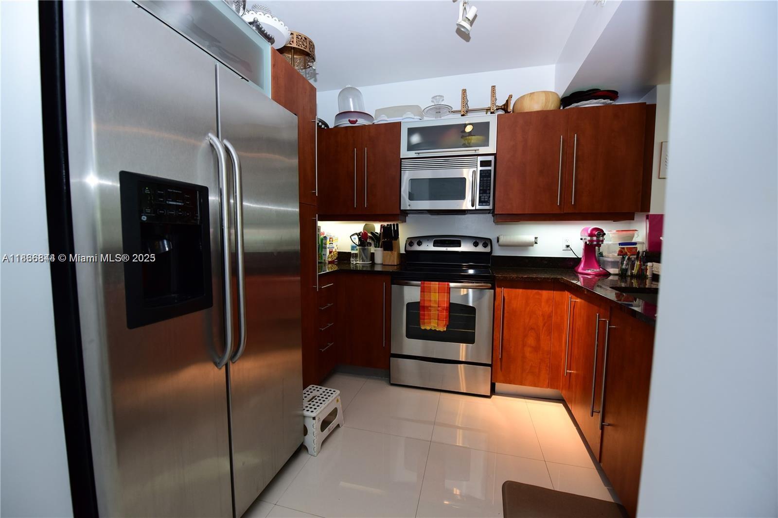 7355 Southwest 89th Street, Unit 622N Miami, FL 33156 - Photo 5 of 16 a kitchen with stainless steel appliances granite countertop a refrigerator and a stove