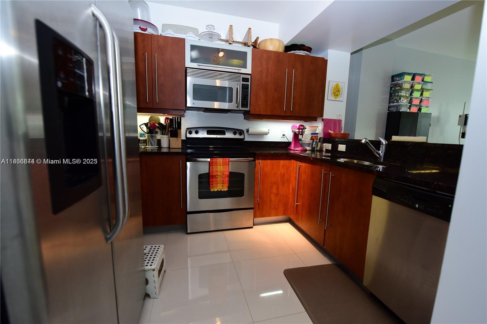7355 Southwest 89th Street, Unit 622N Miami, FL 33156 - Photo 6 of 16 a kitchen with stainless steel appliances granite countertop a refrigerator and a stove