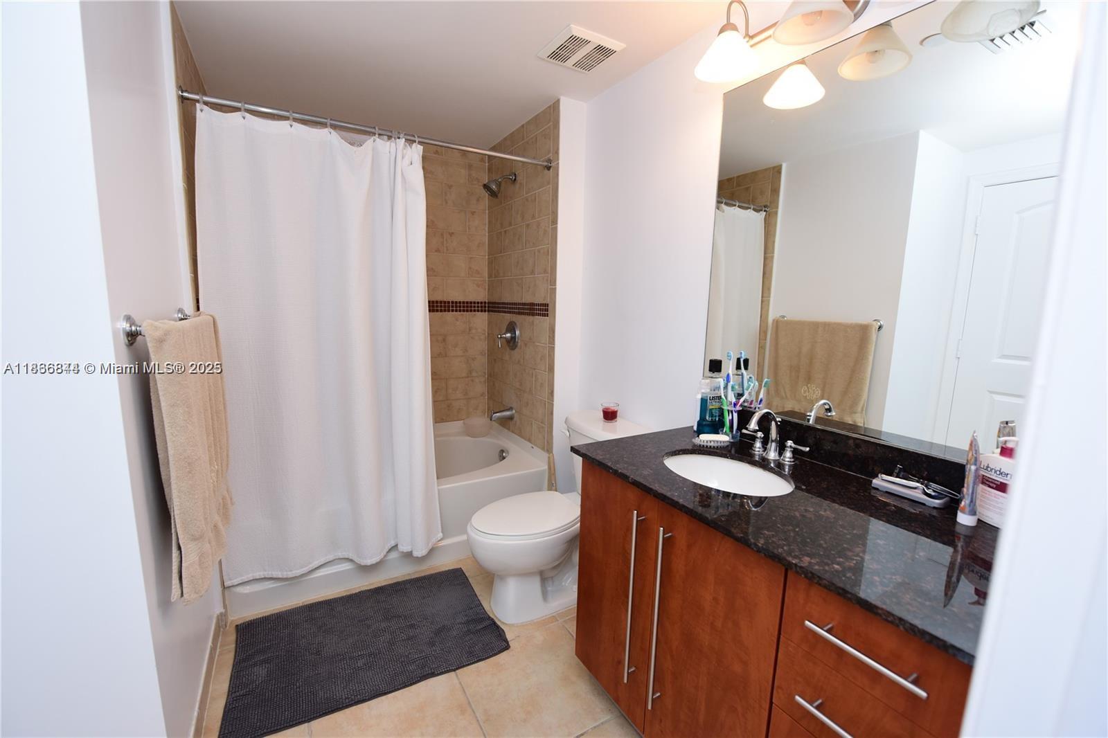 7355 Southwest 89th Street, Unit 622N Miami, FL 33156 - Photo 9 of 16 a spacious bathroom with a double vanity sink toilet mirror and shower