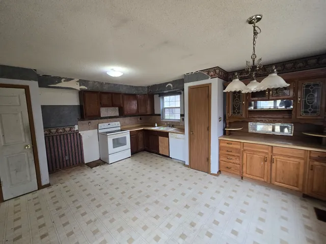 a kitchen with stainless steel appliances granite countertop a refrigerator a stove top oven a sink and dishwasher