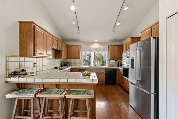 a kitchen with a refrigerator and a stove top oven