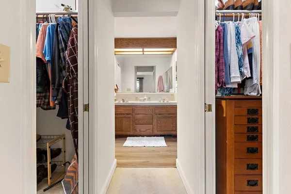 a view of walk in closet with clothes and shoes