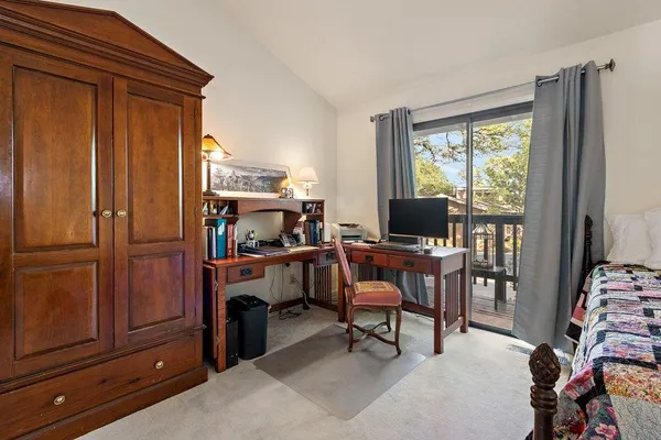 a view of a workspace with furniture and a window