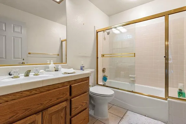 a bathroom with a double vanity sink toilet and shower