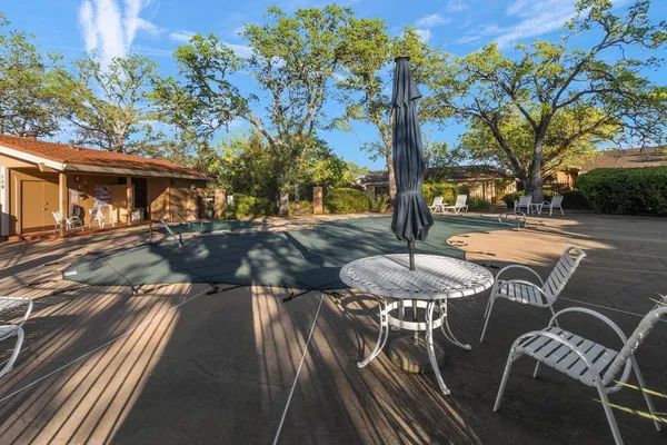 a view of a patio with table and chairs with wooden fence and plants
