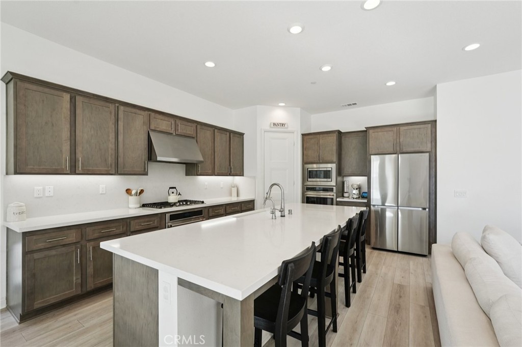 39481 Chamise Temecula, CA 92591 - Photo 8 of 34 a kitchen with stainless steel appliances a stove a sink a refrigerator and cabinets