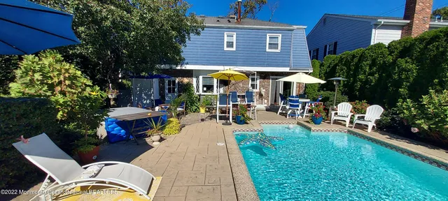a view of a patio with couches table and chairs under an umbrella