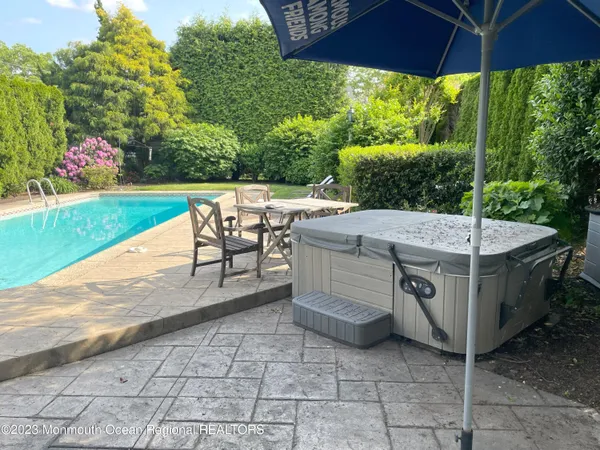 a view of a patio with a table and chairs under an umbrella
