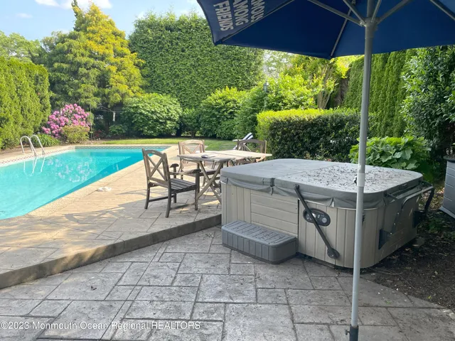 a view of a patio with a table and chairs under an umbrella