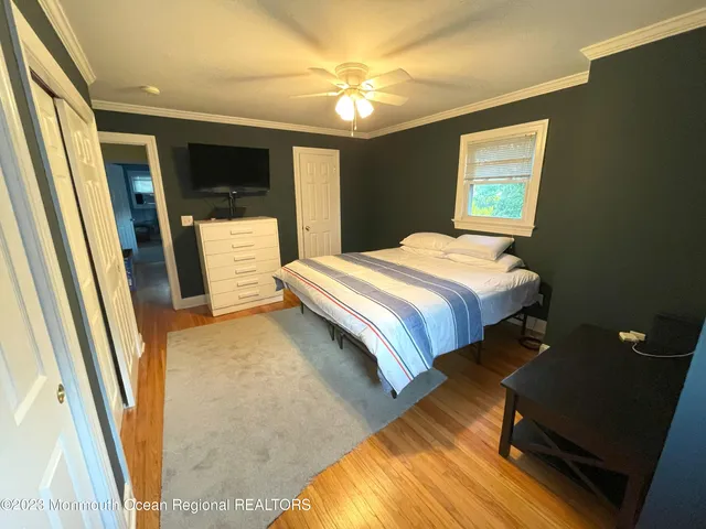 a bedroom with a bed and a flat tv screen on dresser