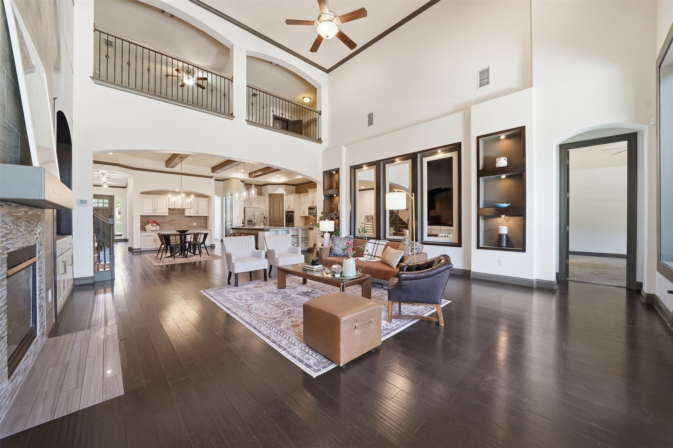 8729 Vantage Point Drive Austin, TX 78737 - Photo 13 of 33 Grand two-story living area with dark hardwood floors, soaring ceilings, and a view of the adjacent kitchen and dining spaces.