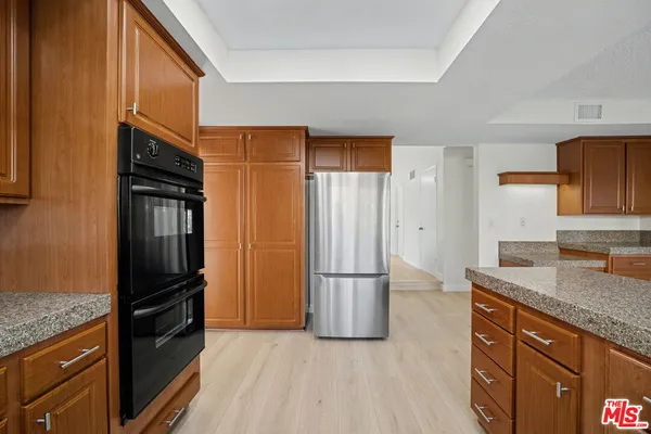 a kitchen with granite countertop a refrigerator stove and kitchen island