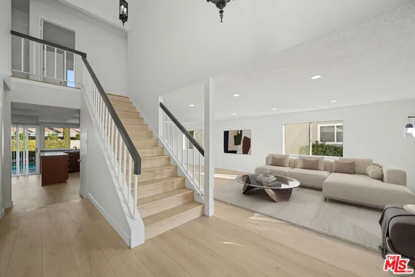 a living room with furniture and stairs