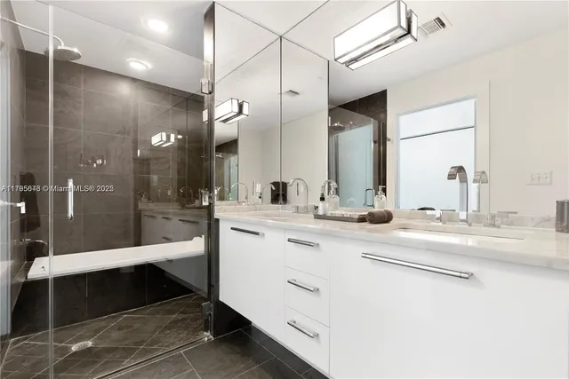 a bathroom with double vanity and a mirror