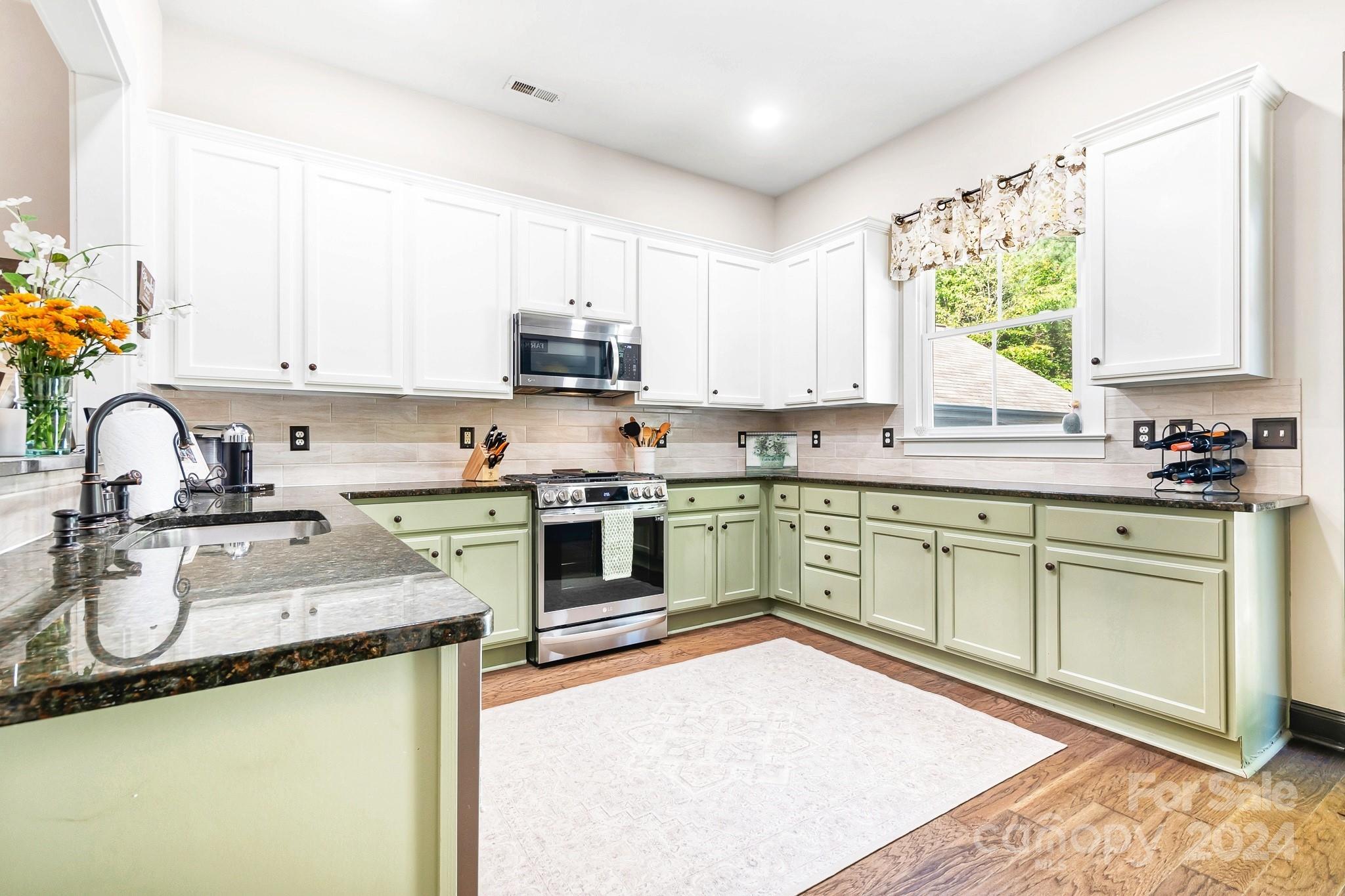 2607 Nations Commons Street Fort Mill, SC 29708 - Photo 11 of 40 a kitchen with stainless steel appliances granite countertop a sink a stove a refrigerator cabinets and a window