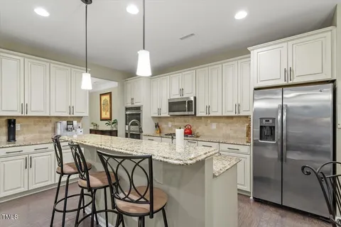 a kitchen with kitchen island granite countertop a sink appliances cabinets and a counter top space