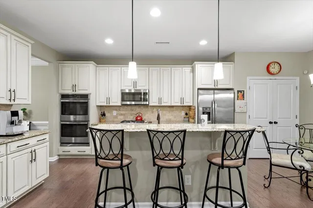 a kitchen with stainless steel appliances granite countertop a stove a microwave and cabinets