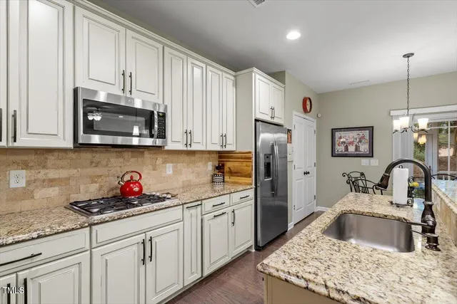 a kitchen with stainless steel appliances granite countertop a sink stove and refrigerator