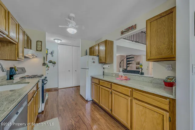 a kitchen with stainless steel appliances granite countertop a sink dishwasher stove and refrigerator with wooden floor