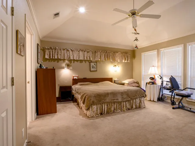 a spacious bedroom with a bed and a chandelier