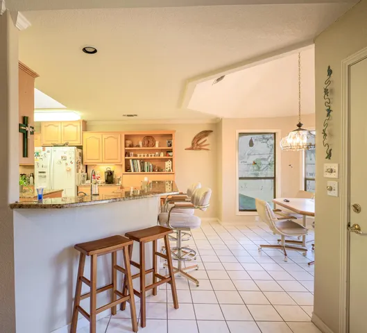a dining room with furniture and a floor to ceiling window