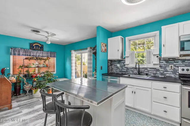 a kitchen with granite countertop a table chairs and wooden cabinets