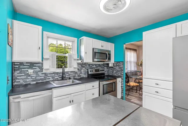 a kitchen with stainless steel appliances granite countertop a stove a sink and a refrigerator