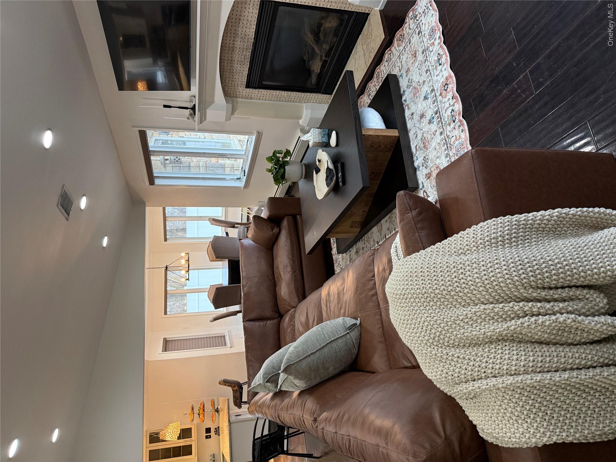 29 Wilton Road Rye Brook, NY 10573 - Photo 17 of 18 Living area featuring visible vents, wood finished floors, recessed lighting, a fireplace, and lofted ceiling